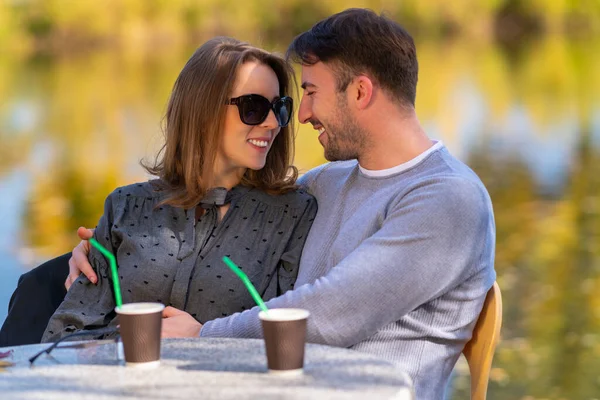 Unga par njuter av en kärleksfull dejt i en park — Stockfoto