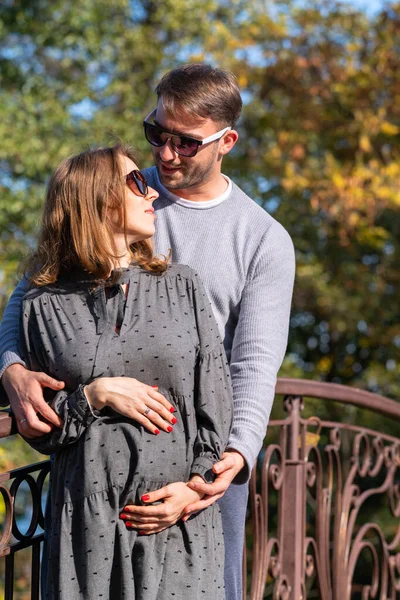 Happy young couple with pregnant woman