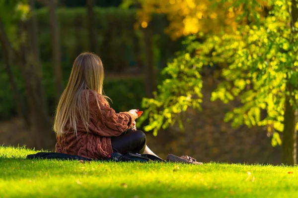 Ung kvinna varva ner i en park på hösten — Stockfoto