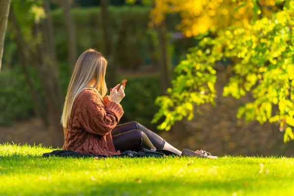 Trendige junge Frau entspannt im Herbst in einem Park — Stockfoto