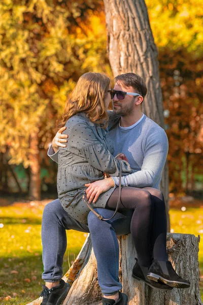 Těhotná mladá žena sedí na svém manželském klíně — Stock fotografie