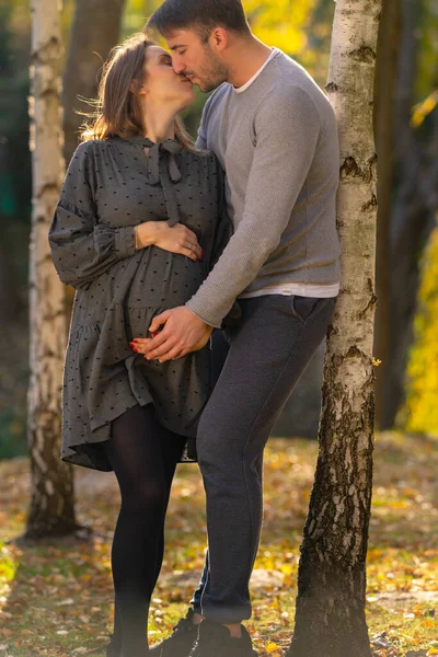 Любящие беременные молодые пары нежно целуются — стоковое фото