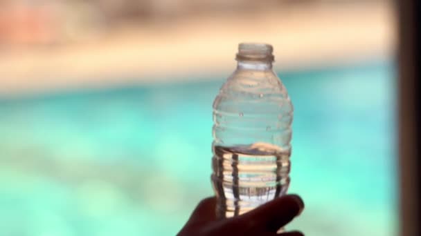 Person öffnet Flaschenwasser für einen Drink — Stockvideo