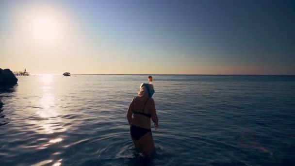 Femme entrant dans la mer pour faire de la plongée avec tuba — Video