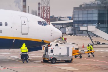 Airport personnel manoeuvring equipment