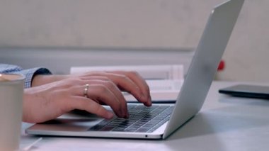 man typing and scrolling on a laptop computer