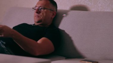 Bored man constantly changing television channels