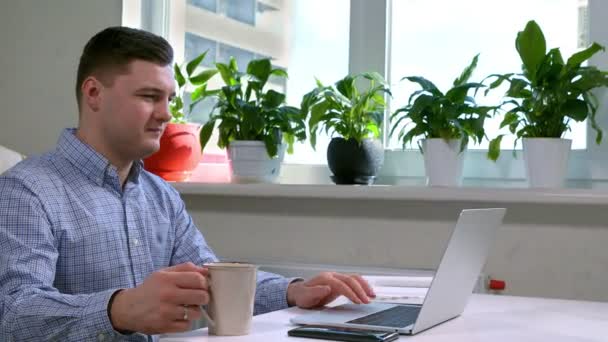 Бизнесмен наслаждается чашкой кофе во время работы — стоковое видео