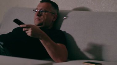 Middle-aged man relaxing watching television