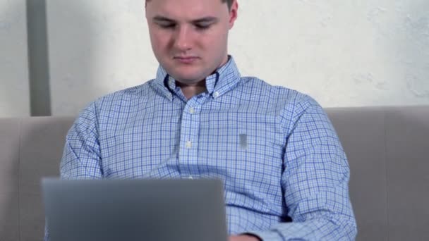 Young man using a laptop on his lap — 图库视频影像