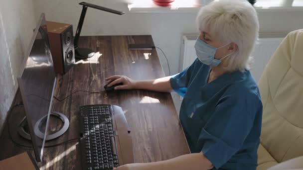 Mujer trabajando en una oficina usando una máscara facial — Vídeo de stock