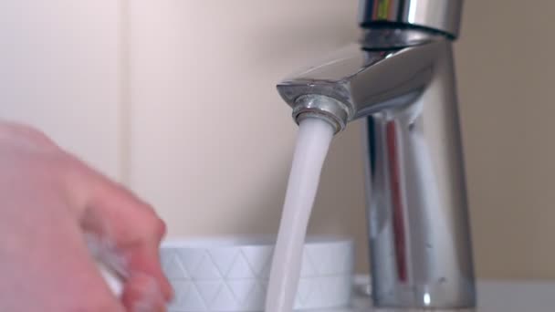 Чоловік миє руки з милом під проточною водою — стокове відео