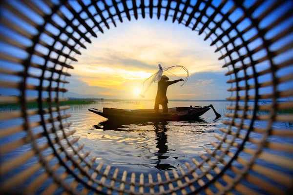 Silhouette fisherman throwing fishing net — Stock Photo, Image