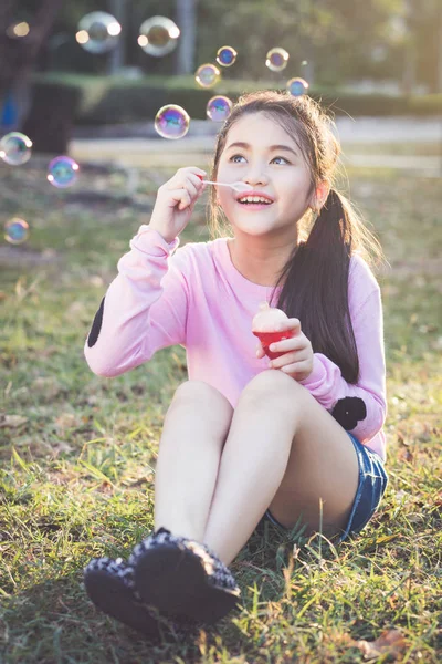 Young girl blowing soap bubbles — Stock Photo, Image