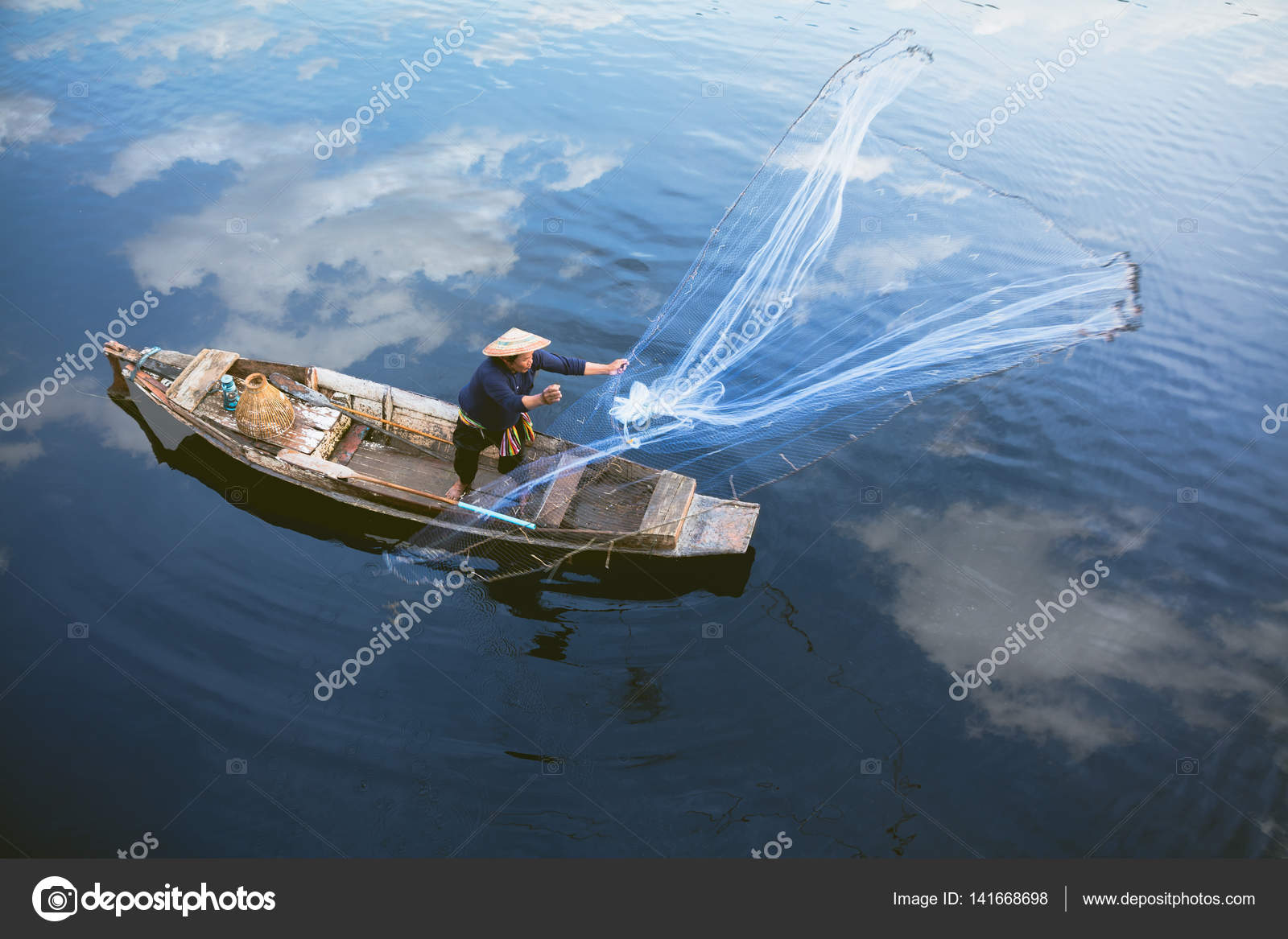Asian fisherman on wooden boat casting a net — Stock Photo © pat138241  #141668698
