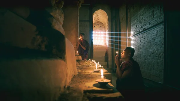 Nowicjuszy, modląc się z Znicze przy posągu Buddy wewnątrz stare pagoda — Zdjęcie stockowe