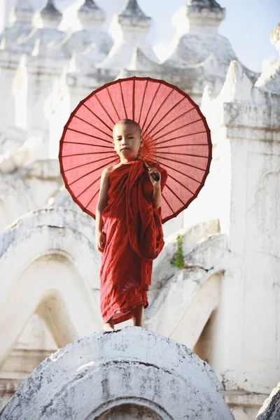 Novices under umbrellas at historic temple — Stock Photo, Image