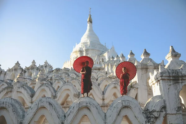 Novices under umbrellas at historic temple — Stock Photo, Image