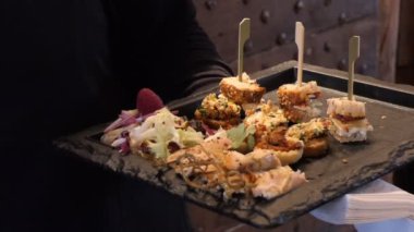 Aperatif tepsisi restoranda tutan kadın