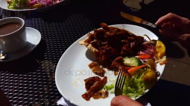 Açık café'de döner kebap yiyen adam