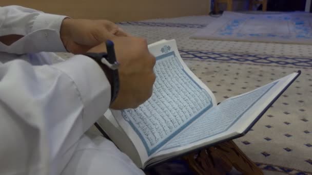 Hombre musulmán convirtiendo el Corán en páginas del Corán — Vídeo de stock