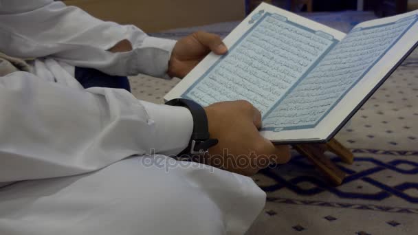 Man in white Muslim robe reading holy Quran — Stock Video