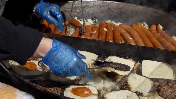 Бургеры и сосиски на сковородке — стоковое видео