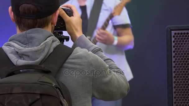 Hombre filmando guitarrista en un concierto — Vídeos de Stock