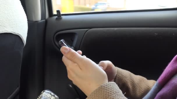 Donna che utilizza il telefono cellulare in un'auto in movimento — Video Stock
