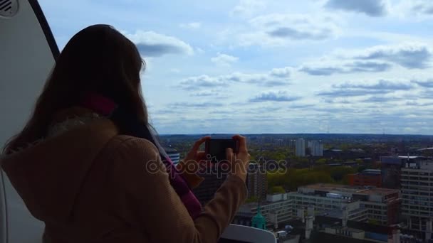 Девушка фотографирует город сверху — стоковое видео