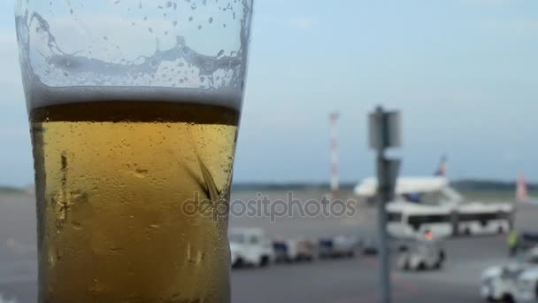 À espera num bar para um voo com um copo de cerveja — Vídeo de Stock