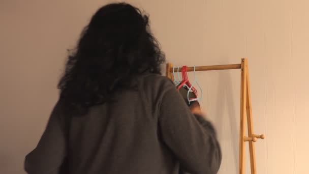 Mujer desnudándose y colgando su chaqueta — Vídeo de stock