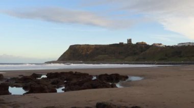 Scarborough beach kum üzerinde siyah taşlar