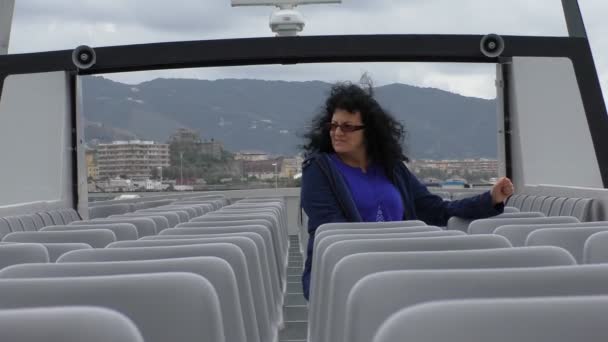 長い黒髪と眼鏡の女性は風の天気予報旅客船 船またはフェリーの一番上のデッキに一人ぼっちで座って — ストック動画