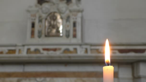 关闭单蜡烛燃烧与其黄色的橙色火焰缓慢移动 以模糊的教堂内部背景 和平的象征 — 图库视频影像