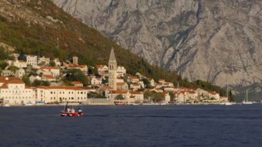 Kırmızı tekne Karadağ kente doğru yelken turist taşıyan Perast Adriyatik Denizi Kotor Körfezi kıyısında yer alır. Alacakaranlıkta deniz ve dağ manzarası