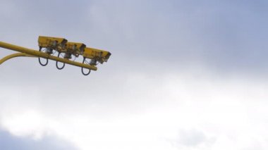 Üç sarı renk ortalama hız kameraları bulutlu gökyüzü karşı düşük açılı görünümü