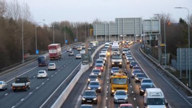 Manchester, İngiltere, Birleşik Krallık - Şubat, 2018: Yüksek açı görüntülemek taşıma her türlü çok yavaş M60 otoyolda hız kameraları geçmiş kış akşamları sürüş ışıkları ile