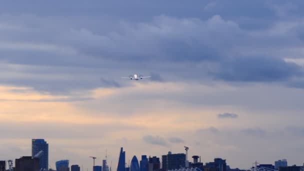 夕暮れ時 暗いスカイラインを背景にロンドン シティ空港から航空機が離陸 ズームイン — ストック動画