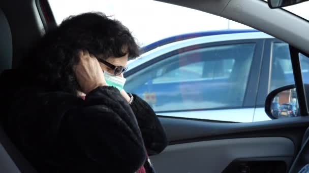 Kobieta Średnim Wieku Okularach Siedzi Samochodzie Zakłada Maskę Chirurgiczną Potem — Wideo stockowe