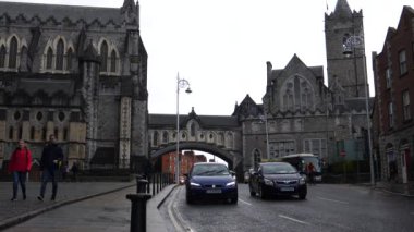 DUBLIN, IRELAND - 2019: Dublin 'deki İsa Kilisesi Katedrali' nden geçen arabalar ve insanlar.