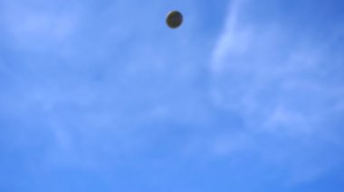 Bir sürü parlak İngiliz poundu düşüyor ve mavi gökyüzü arka planına çarpıyor.