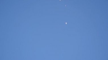 Çerçevenin tepesinden mavi gökyüzü arkaplanına doğru düşen ışıltılı maytap kıvılcımları, bir sürü kopya alanı.