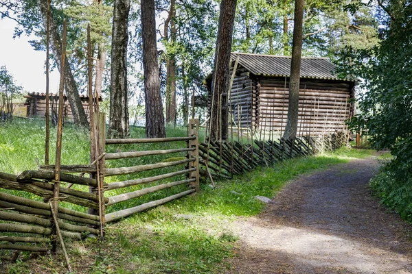 Vecchio recinto di legno e una strada — Foto Stock