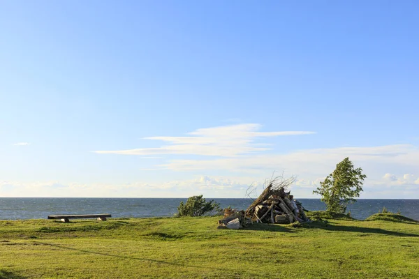 Bench and bonfire set near sea — Stock Photo, Image