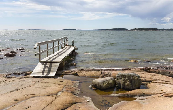 Kleine voet brug over rotsen in de zee — Stockfoto