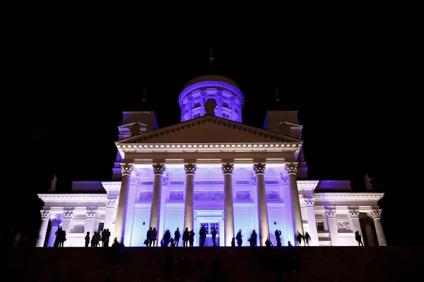 People stant in front of illuminated Helsinki St Nicholas cathed — Stock Photo, Image