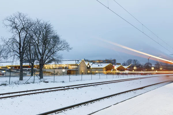 Rails in snow and light strips of trains — ストック写真