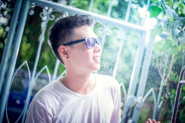 Yağmur yağar, damlalar yüzüne düşer ve çocuk çevresindeki hayat ve doğa, doğa ve mutlu hayat kavramından mutlu olur.