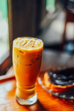 Büyük bardakta buzlu kahve ya da kafe latte koyu ahşap arka planda fotokopi alanı ile birlikte.